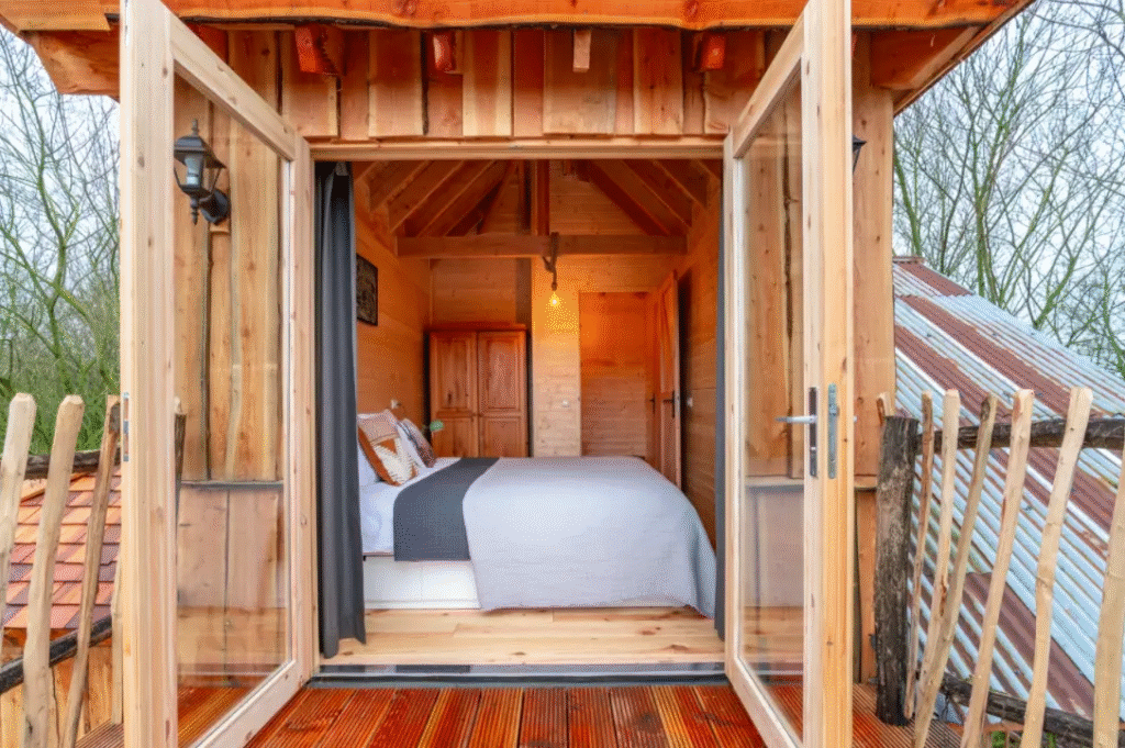 Slaapkamer met openslaande deuren in boomhut Drenthe