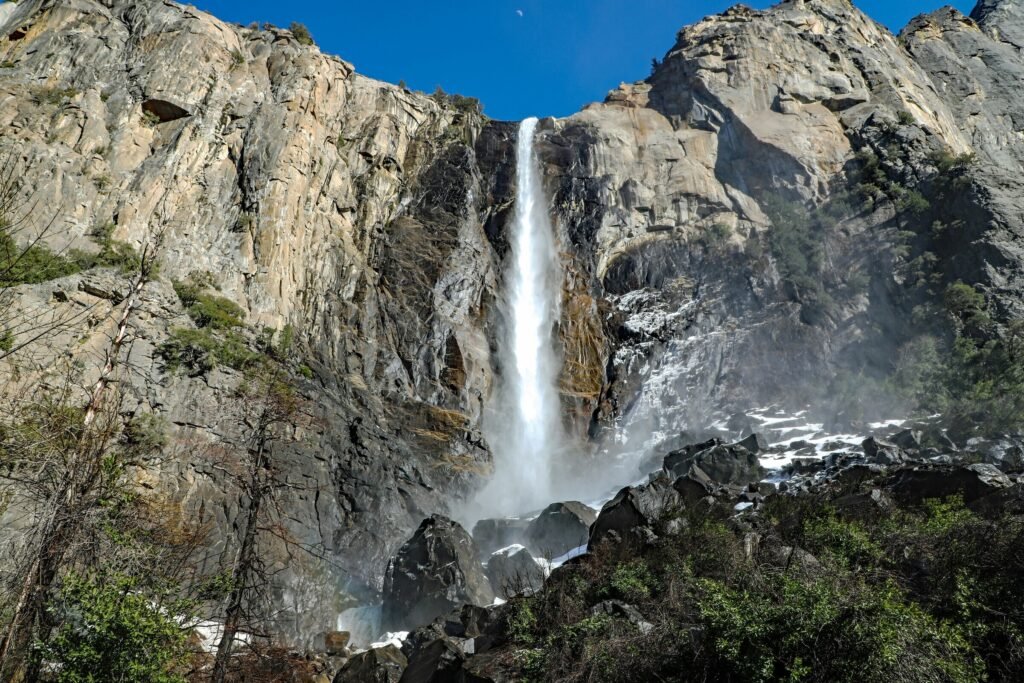 Bridalveil Fall in Yosemite National Park, een 189 meter hoge waterval omringd door rotswanden en bomen.