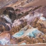 Kleurrijke rotshellingen van Artist’s Palette in Death Valley: zachte roze, groene, paarse en oranje banden in een ruig woestijnlandschap.