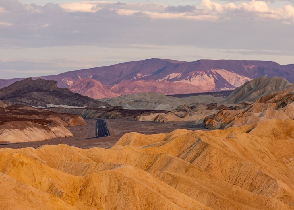 Gouden rotswanden van Golden Canyon in Death Valley: smalle kloof met gelaagde, geelbruine rotsformaties en een kronkelend pad door het droge landschap.