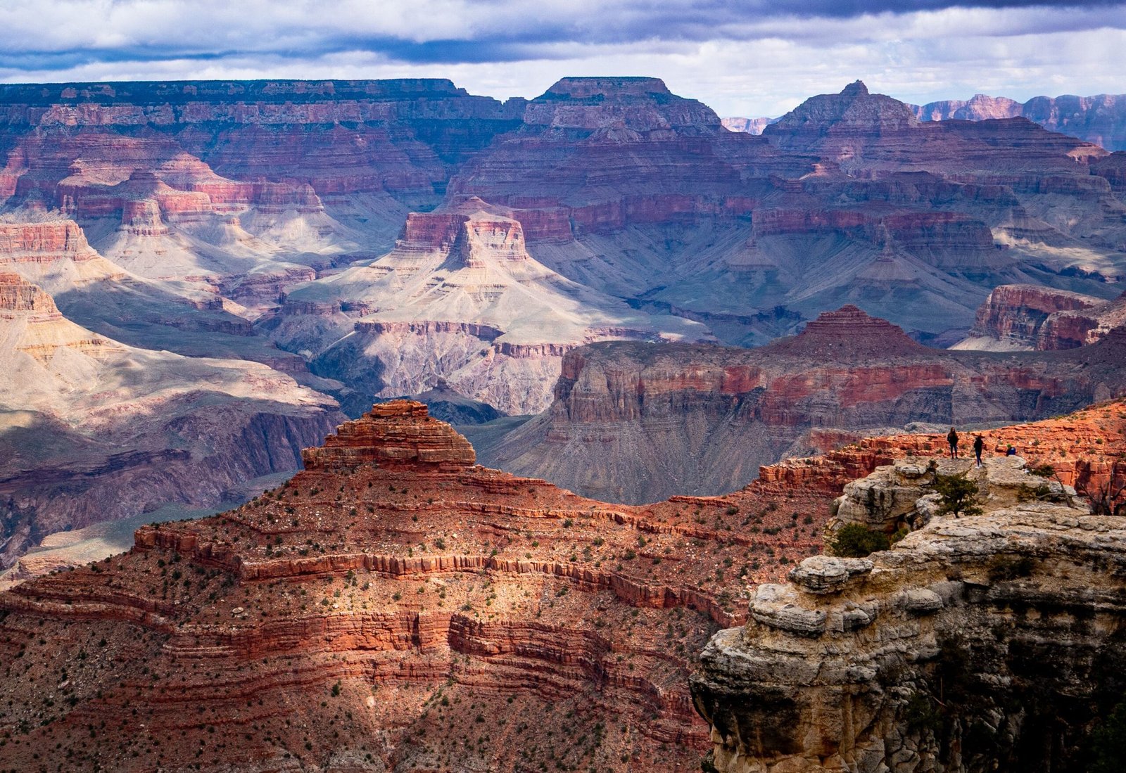 Panoramisch uitzicht over de Grand Canyon South Rim met kleurrijke rotslagen, diepe kloven en de canyon die zich tot aan de horizon uitstrekt.