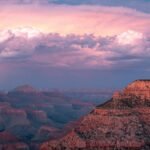 Panoramisch uitzicht vanaf Yavapai Point aan de South Rim van de Grand Canyon met een bliksemschicht die inslaat in de diepe kloof, omringd door donkere onweerswolken.