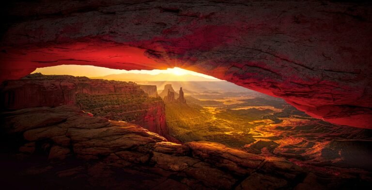 Mesa Arch, een natuurlijke zandstenen boog met uitzicht op de diepe canyons en rotsformaties van Canyonlands National Park.