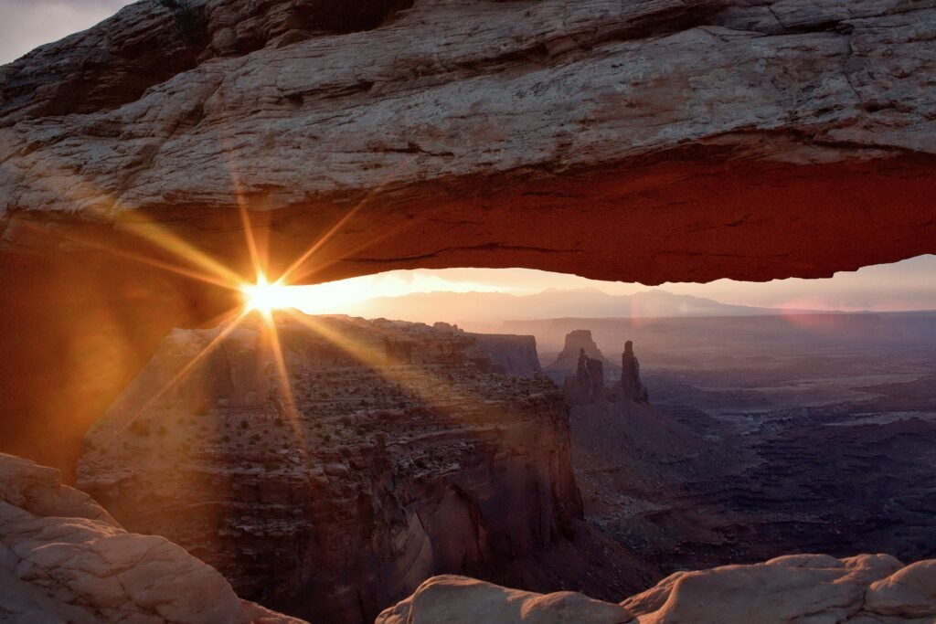 Mesa Arch, een natuurlijke zandstenen boog met uitzicht op de diepe canyons en rotsformaties van Canyonlands National Park.